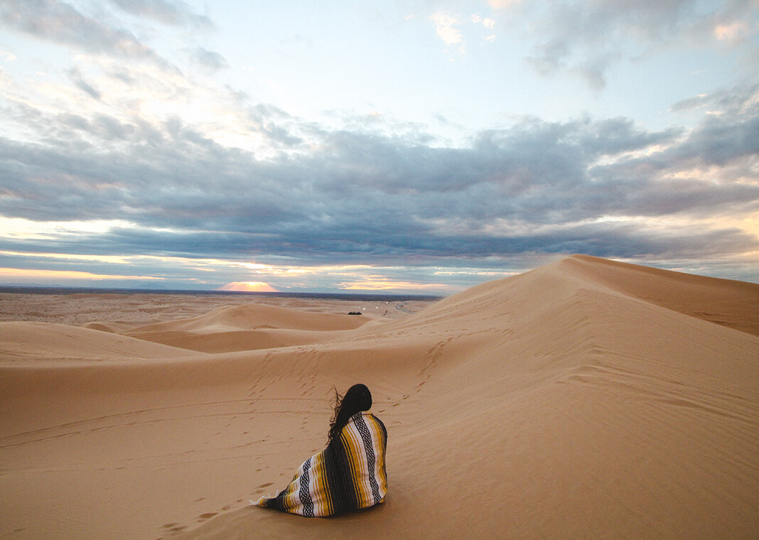 woman sitting in the desert - photo by Jeremy Bishop on Unsplash 