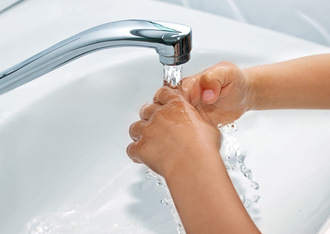 child washing hands in bathroom sink - g215/iStock/Getty Images