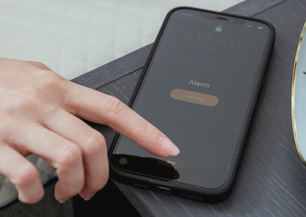 woman turning off phone alarm - photo by Miriam Alonso on Pexels