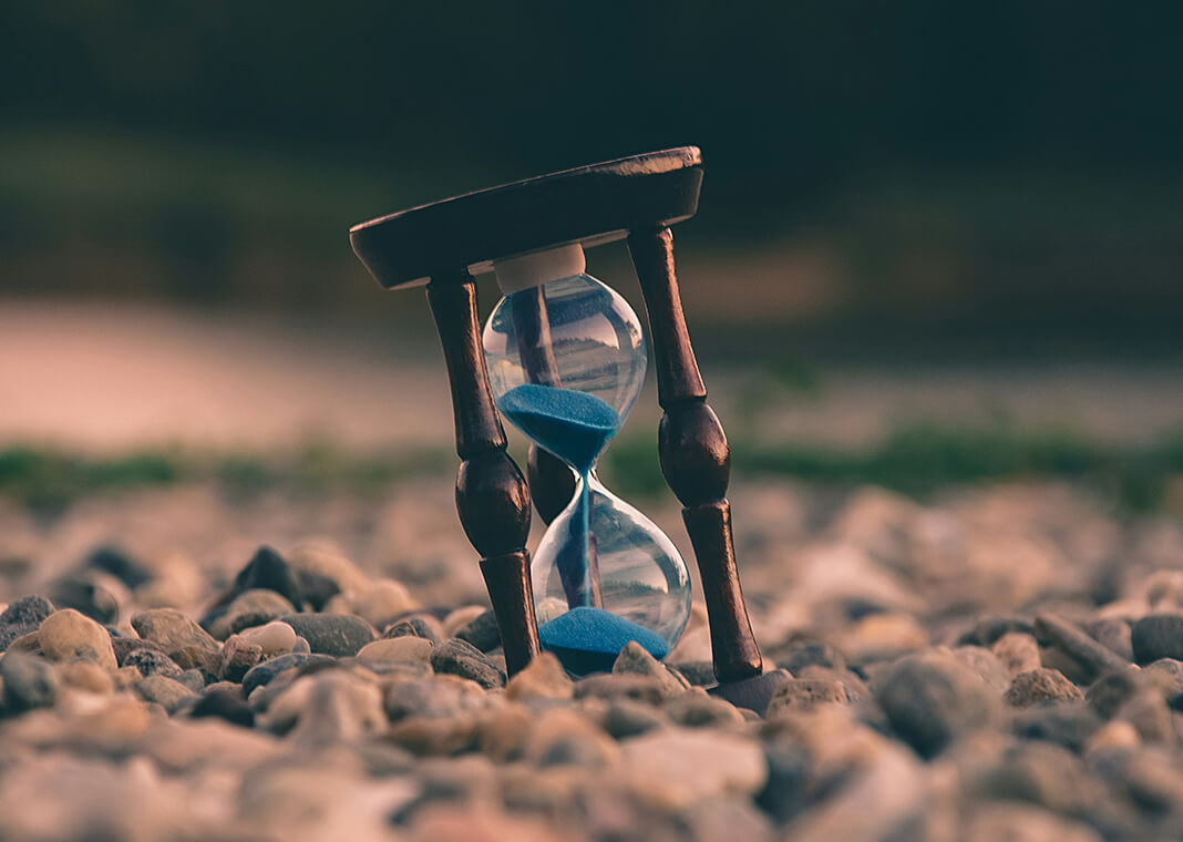 hourglass with blue sand - photo by Aron Visuals on Unsplash