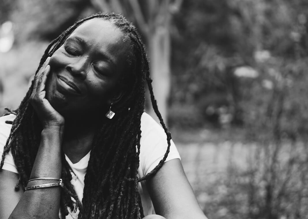 woman resting head in arm, sitting outside - photo by Eye for Ebony on Unsplash