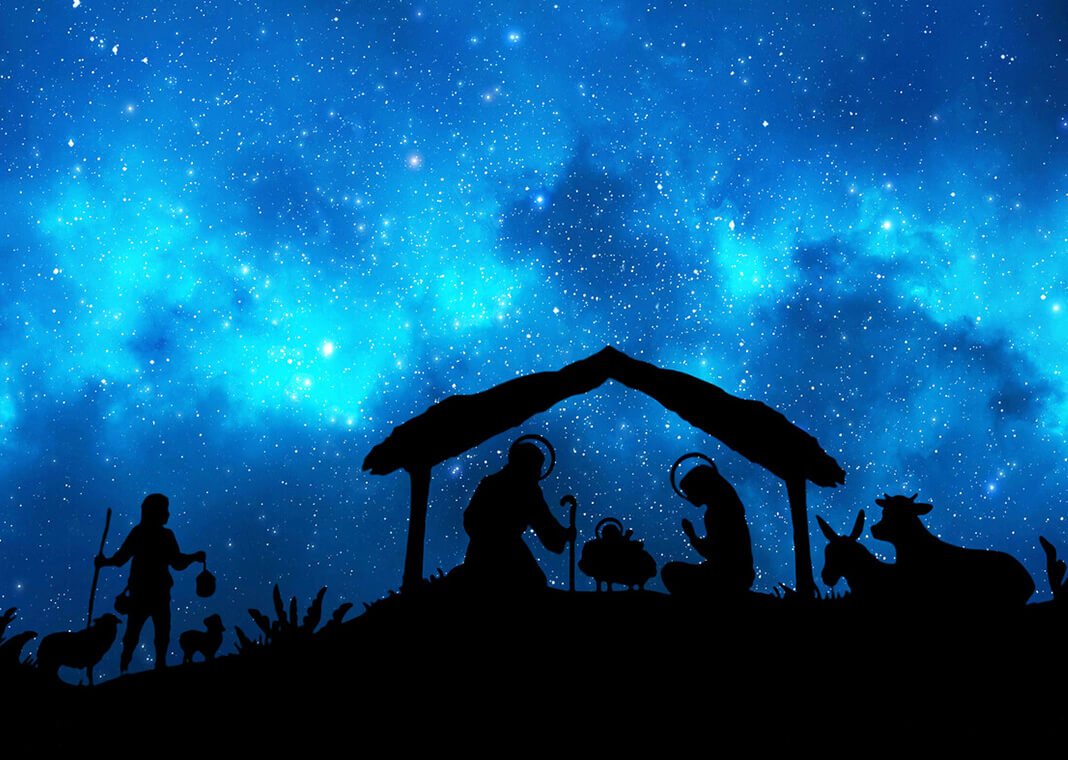 Nativity scene with shepherd arriving against dark blue night sky - lukbar/iStock/Getty Images