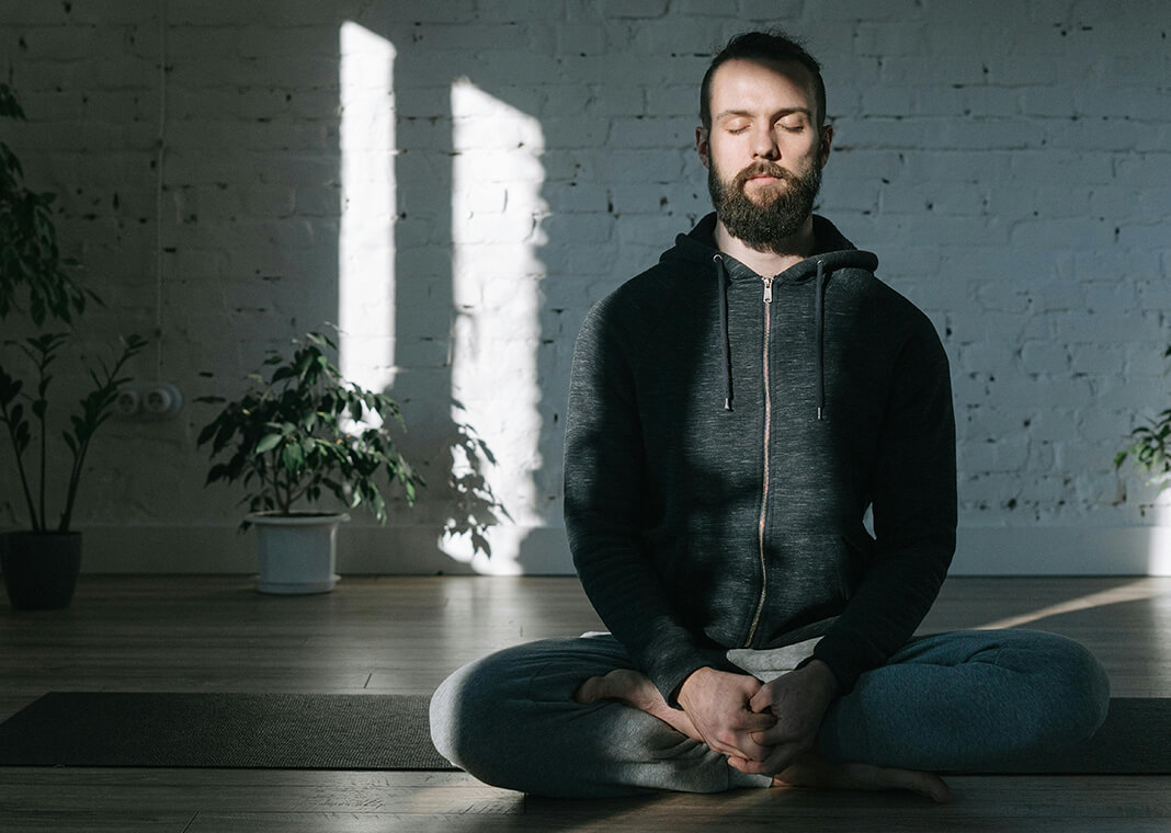 man sitting cross-legged while meditating - photo by Ivan Samkov on Pexels